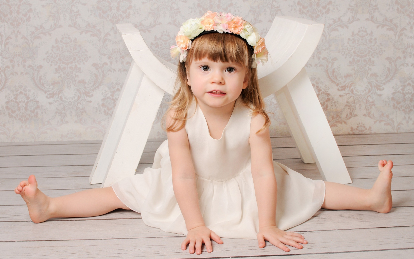 Маленькая девочка сидит на шпагате