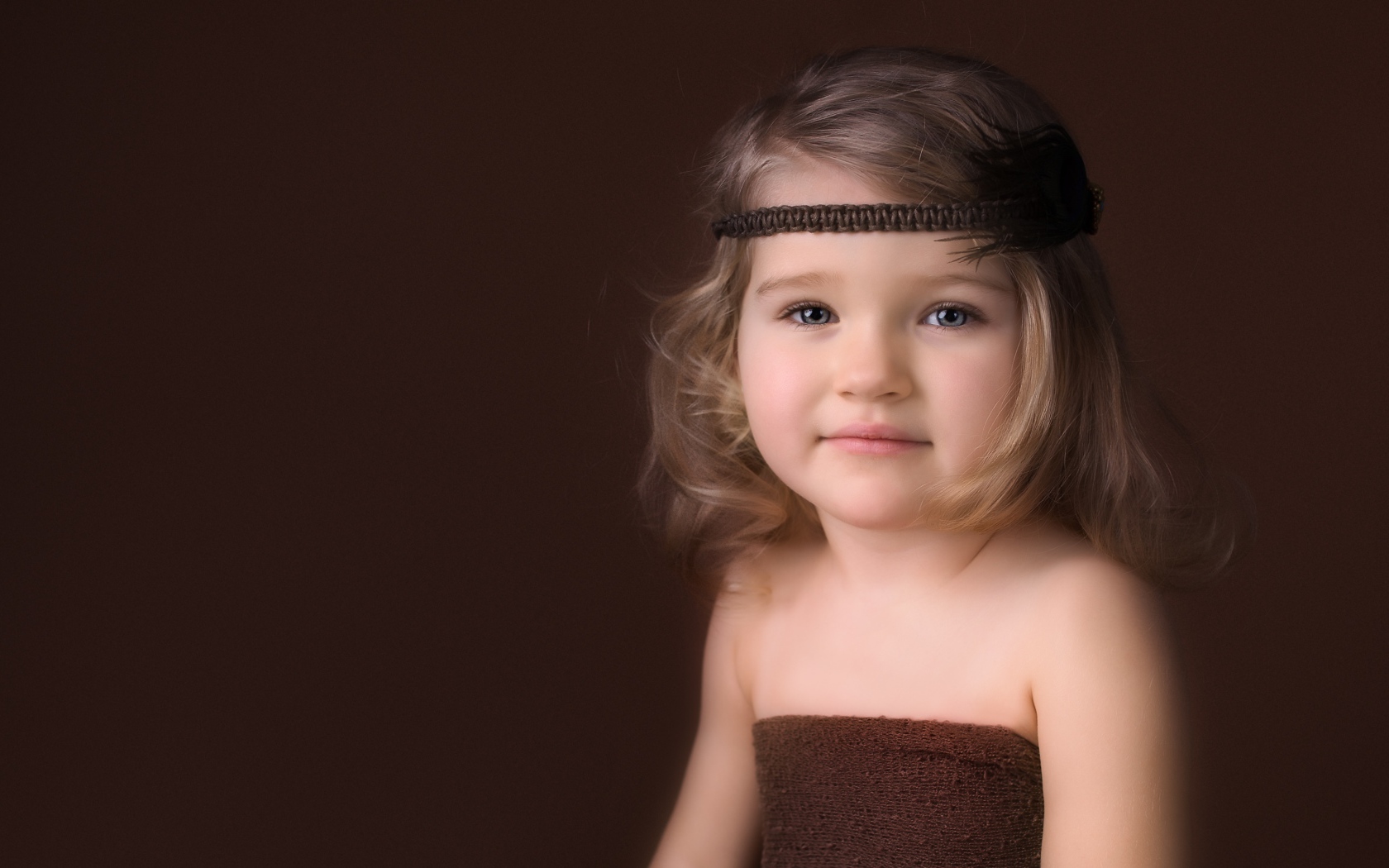 Маленькая девочка с повязкой на голове фото на коричневом фоне