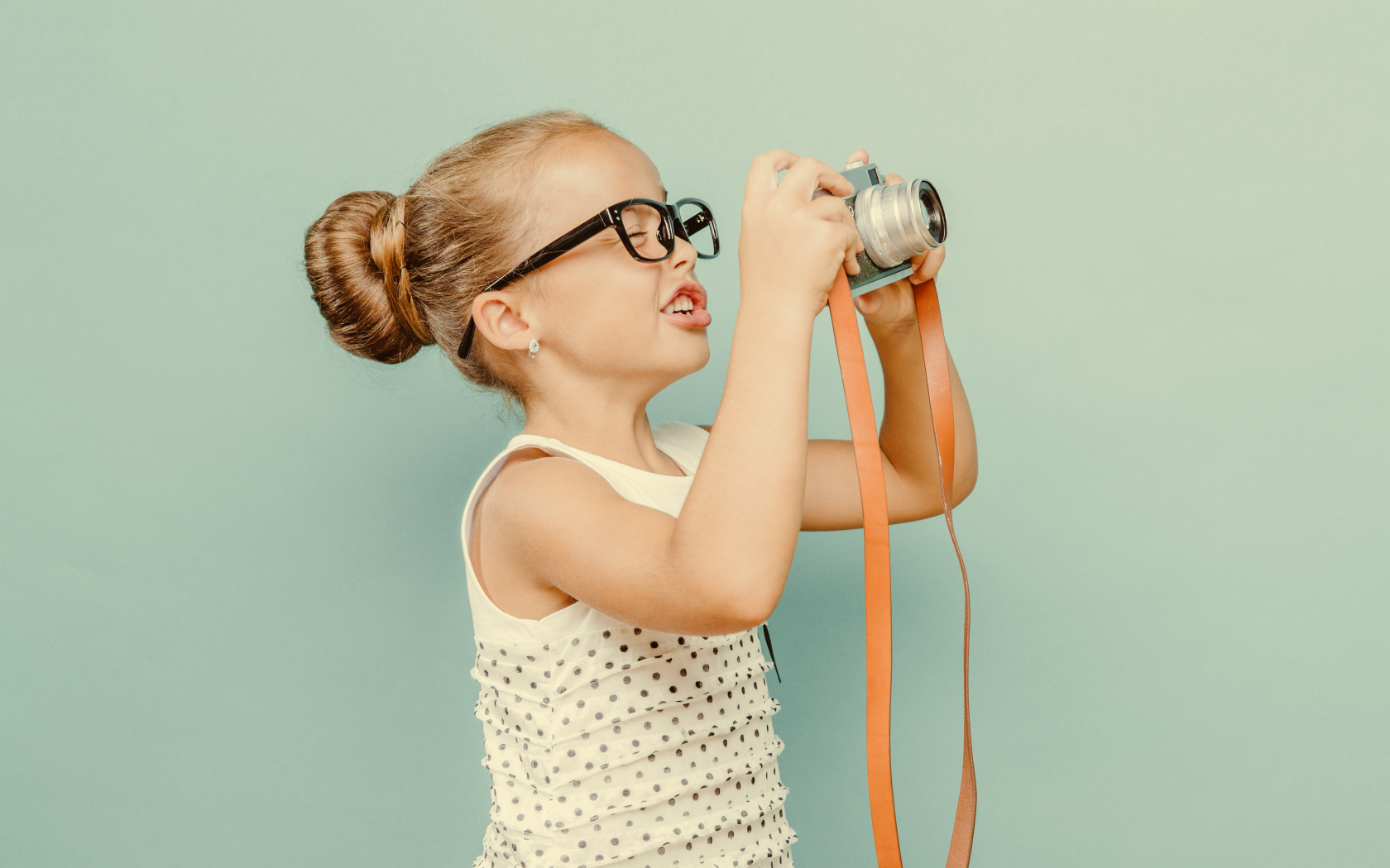 Маленькая девочка в очках с фотоаппаратом