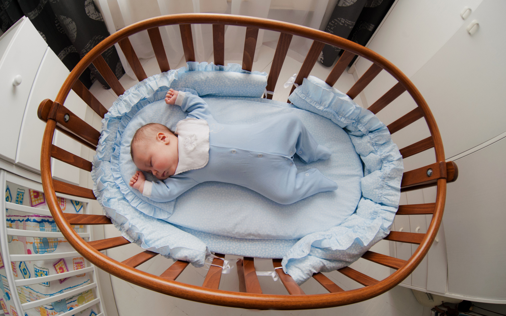 Спящий грудной ребенок в кроватке