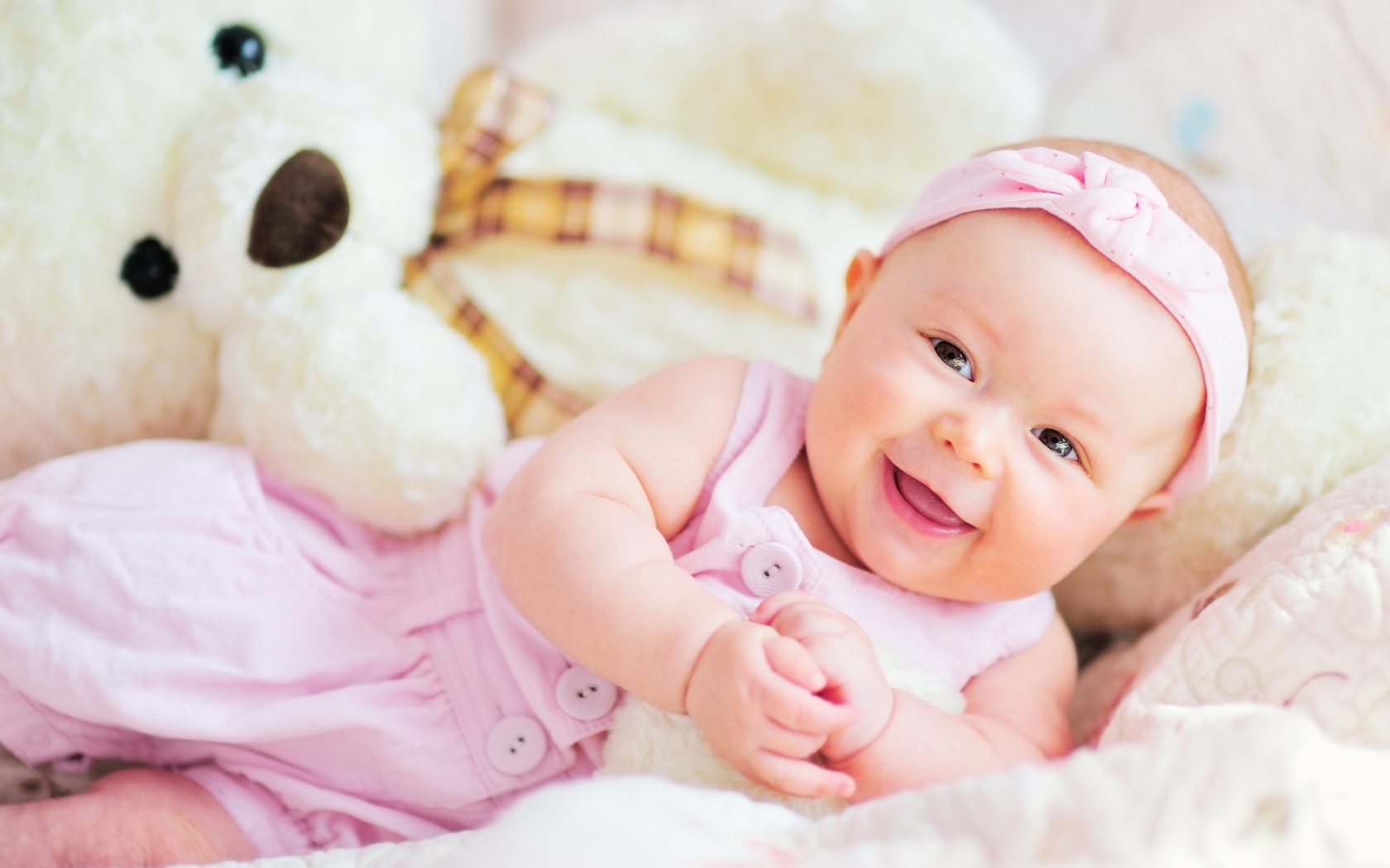 Улыбающаяся маленькая девочка с большим плюшевым медведем