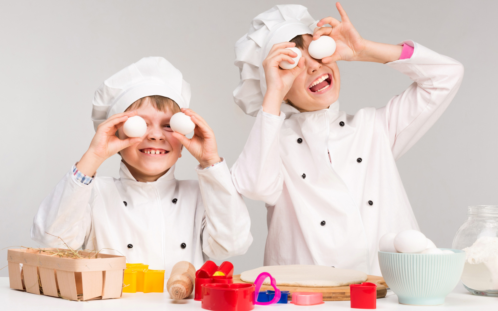 Два маленьких мальчиках в костюмах повара на кухне