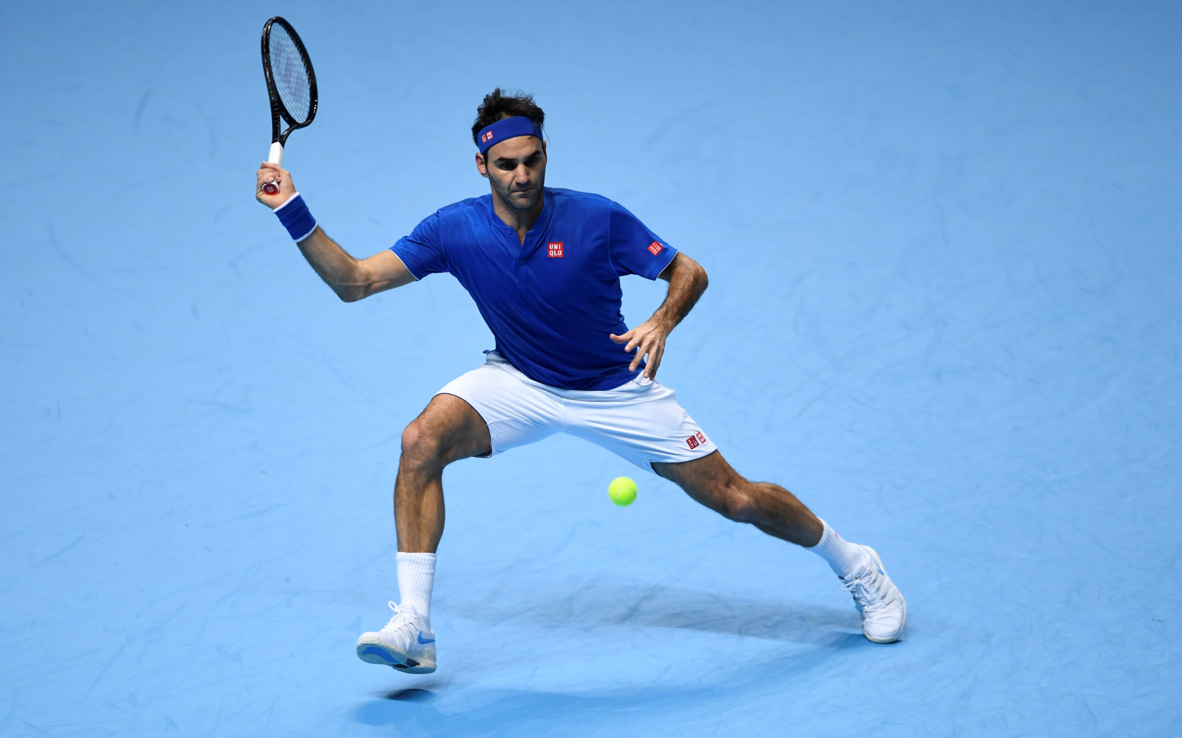 Теннисист Роджер Федерер отбивает мяч ракеткой на корте 