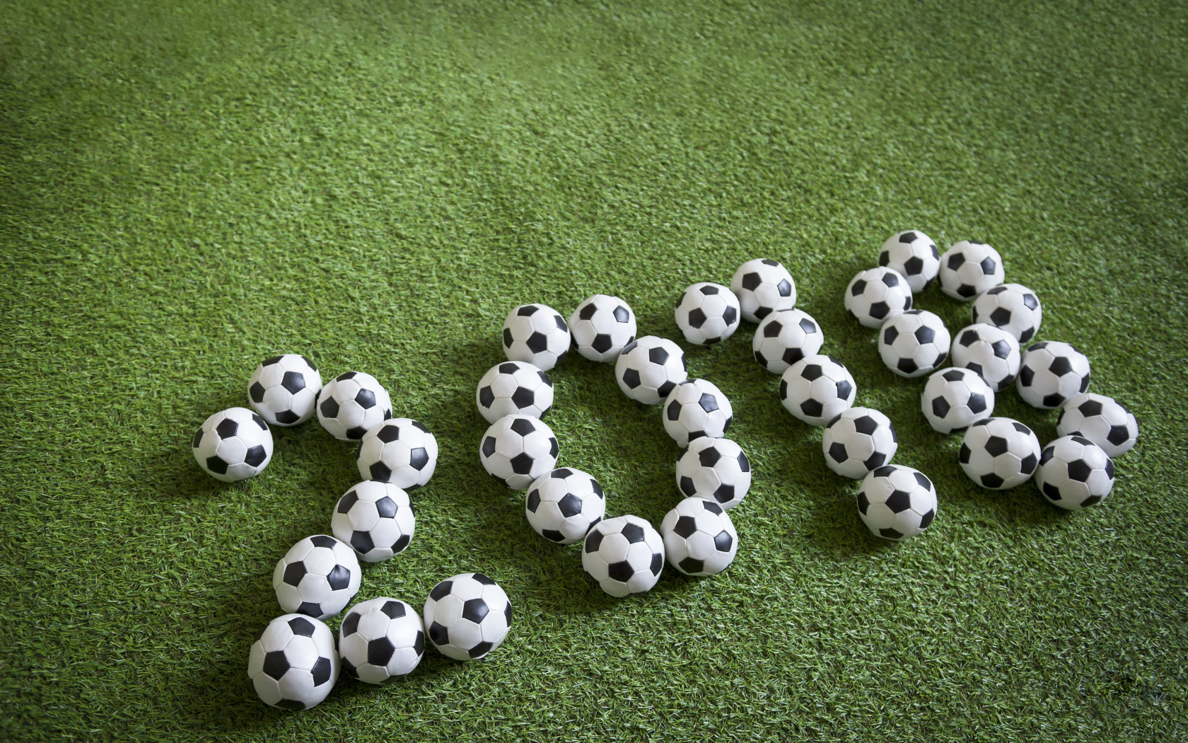 Цифры 2018 из футбольных мячей на зеленой траве