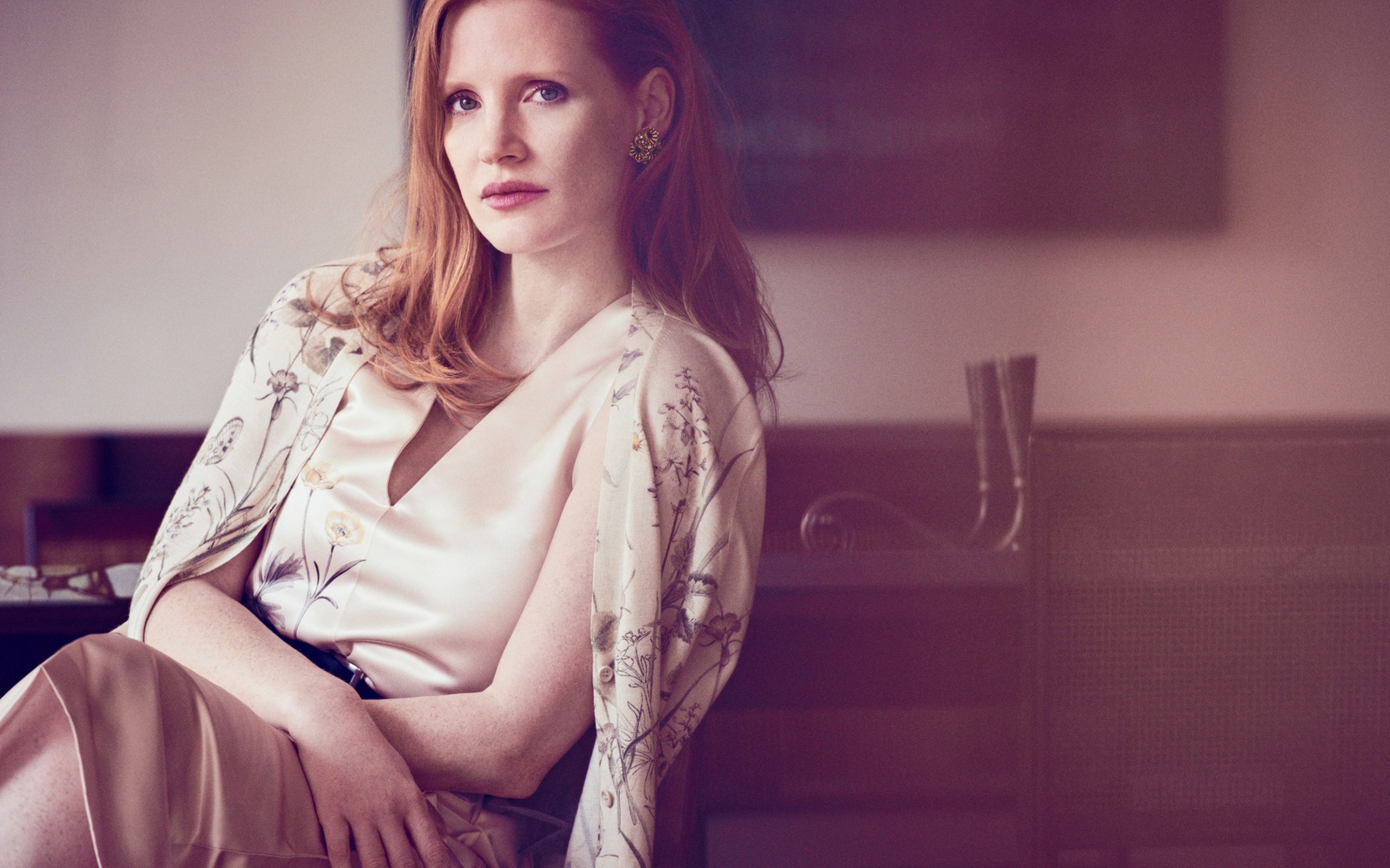 Молодая рыжеволосая актриса Джессика Честейн сидит на стуле