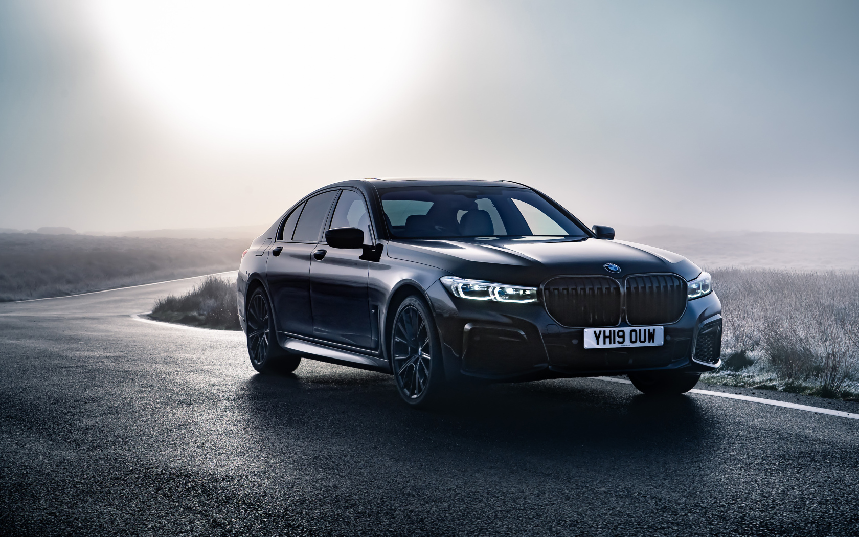 Черный автомобиль BMW 750i xDrive M Sport 2019 года на дороге 