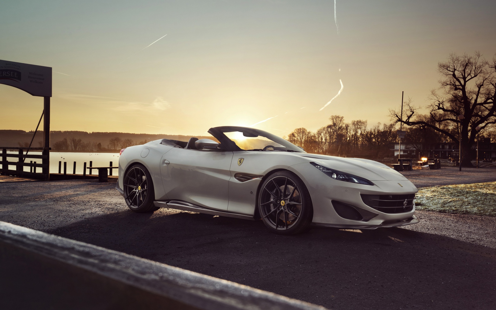 Серебристый кабриолет Ferrari Portofino 2019 года на фоне заката