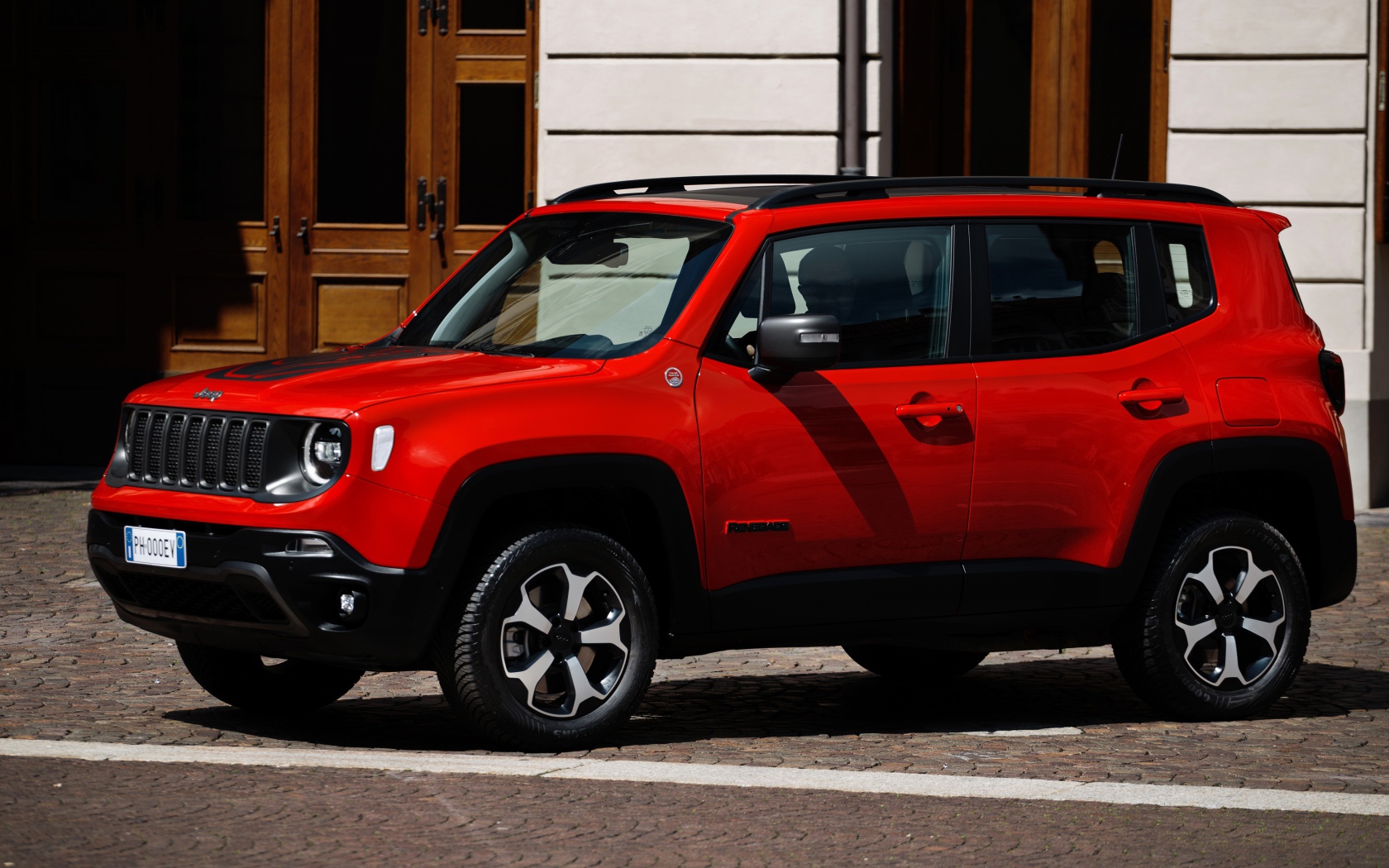 Красный Jeep Renegade Trailhawk Plug-In Hybrid, 2019 года у здания