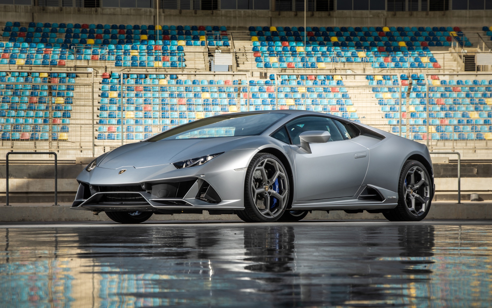 Серебристый автомобиль Lamborghini Huracan Evo на стадионе