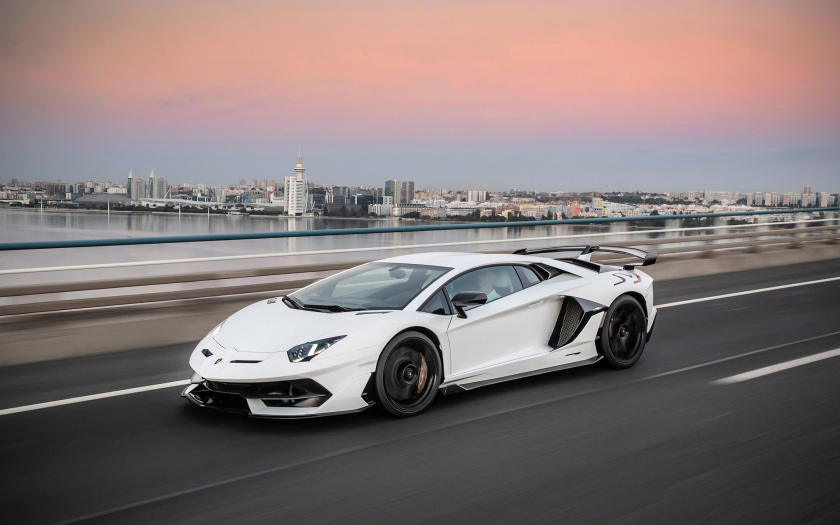 Белый автомобиль Lamborghini Aventador на трассе