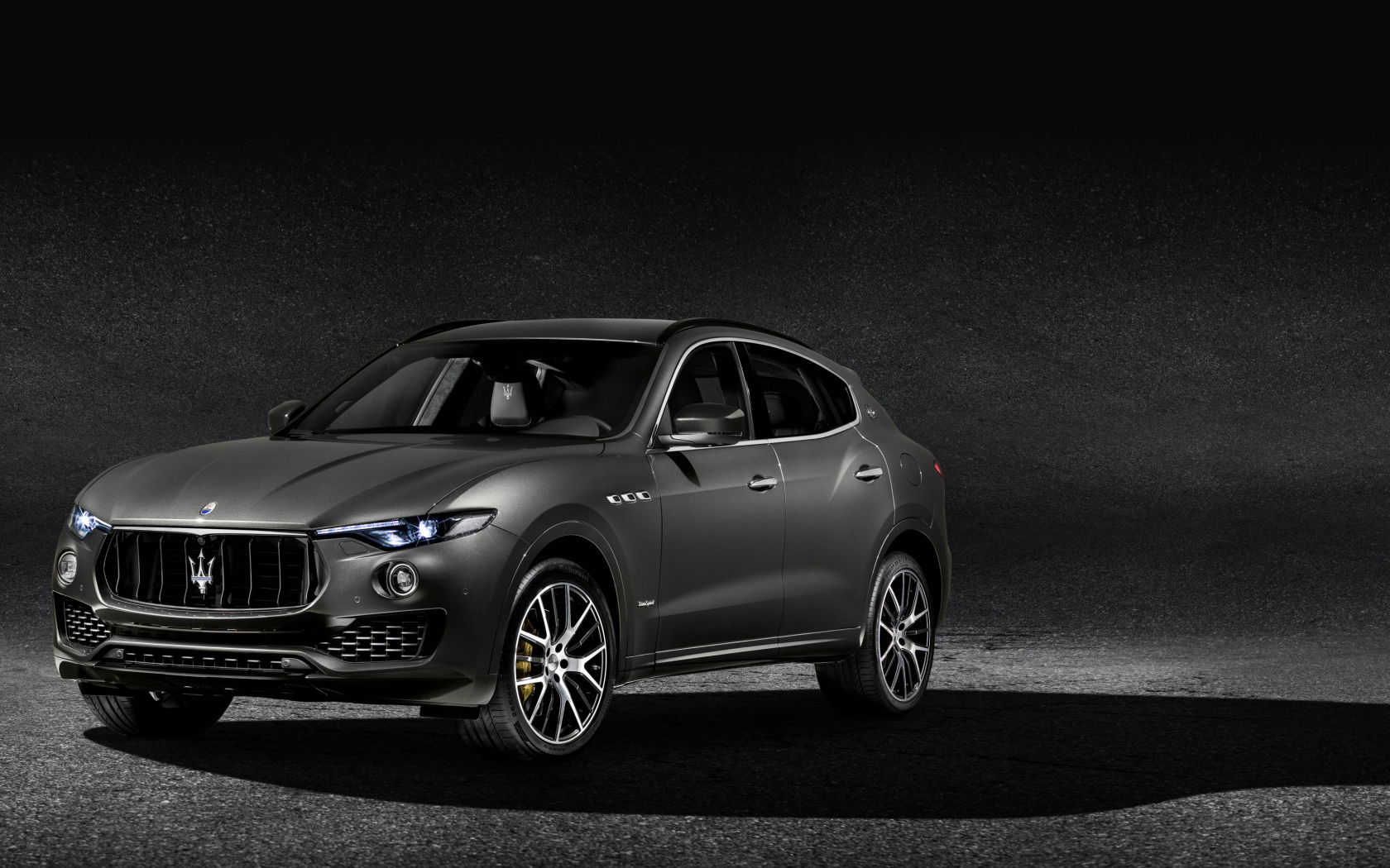 Автомобиль Maserati Levante на сером фоне