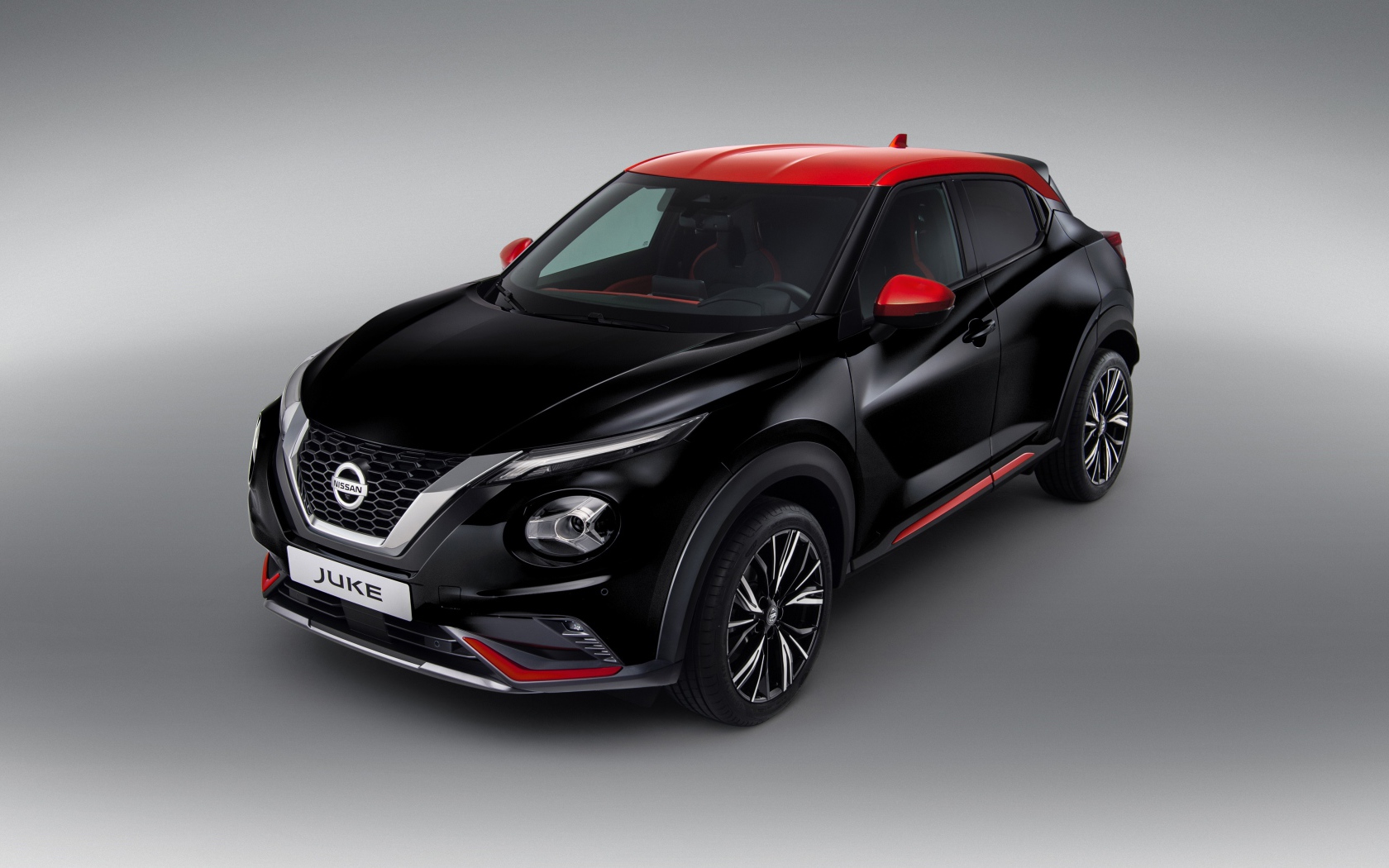 Черный автомобиль Nissan Juke 2019 года на сером фоне