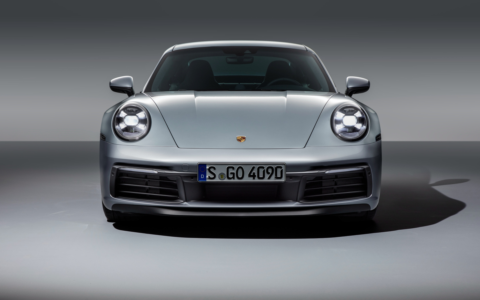 Серебристый автомобиль Porsche 911 Carrera 4S 2019 вид спереди