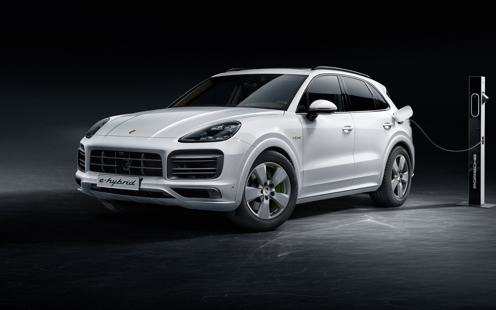 Белый внедорожник Porsche Cayenne E-Hybrid 2018 года на заправке 