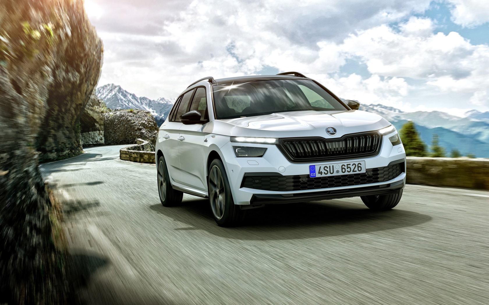 Белый внедорожник Skoda Kamiq Monte Carlo 2019 года на фоне неба в горах