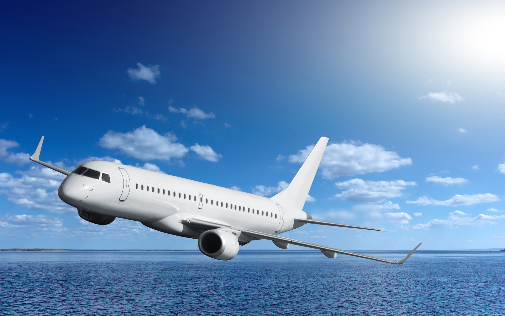 Большой белый пассажирский самолет летит над морем