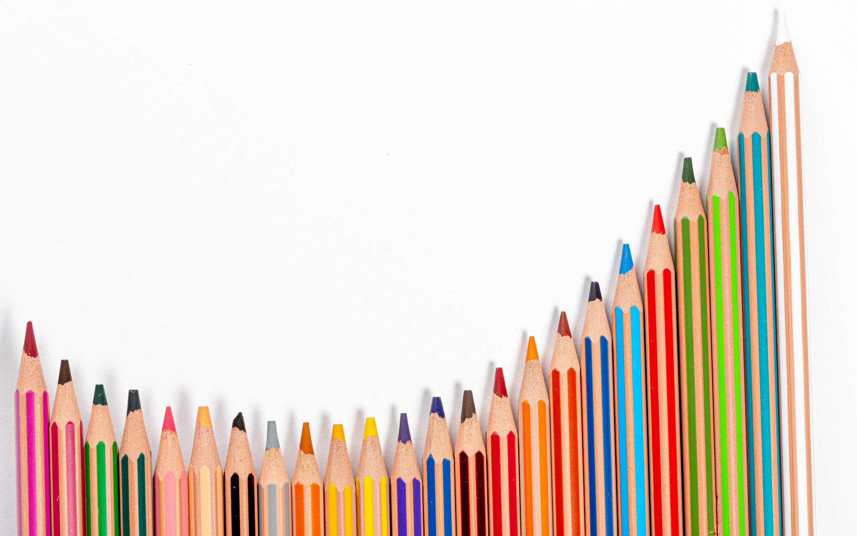 Много разноцветных карандашей на белом фоне