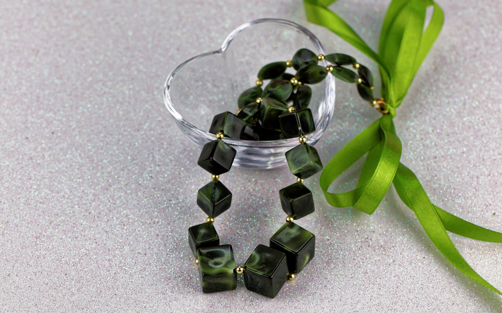 Ювелирное изделие с  бантиком в стеклянной вазочке на столе