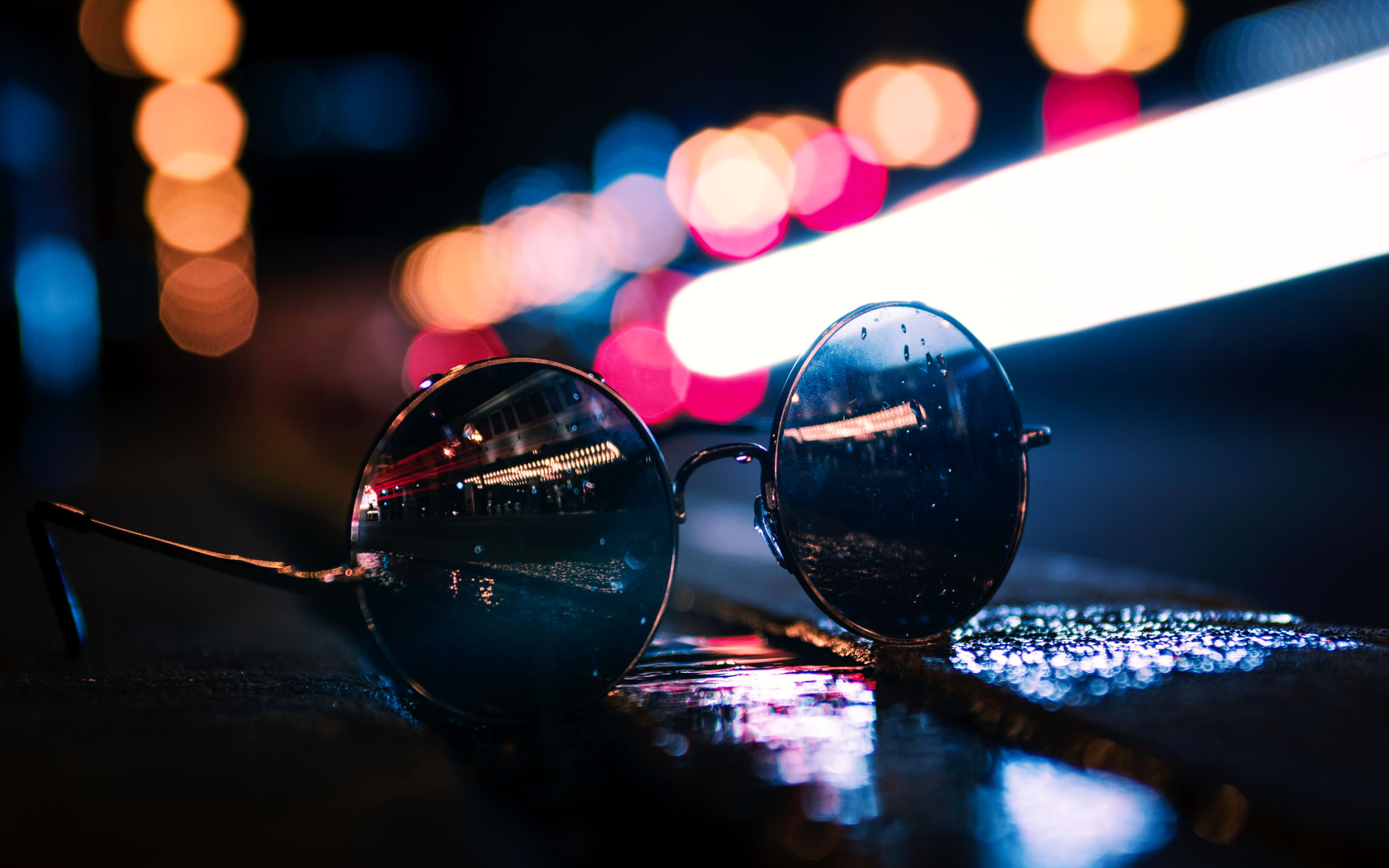 Солнцезащитные очки лежат на мокром асфальте