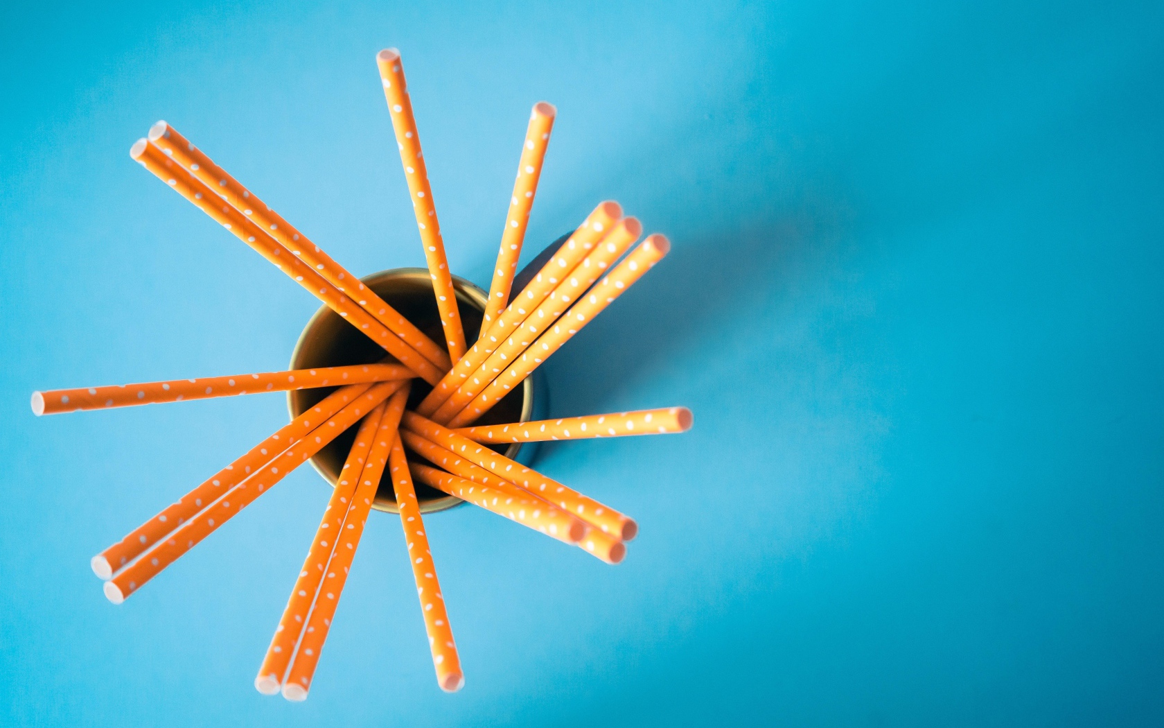 Трубочки в стакане на голубом столе