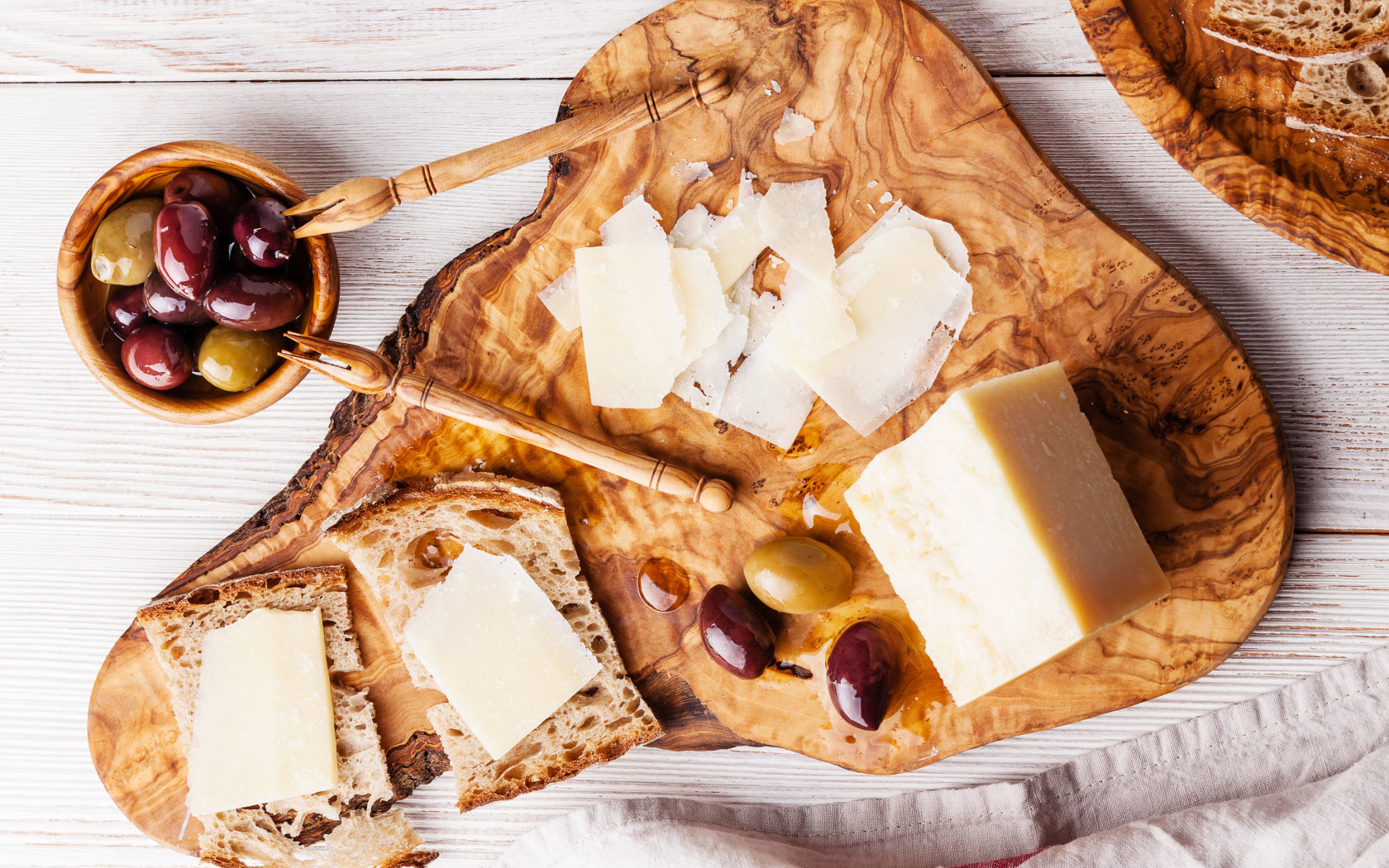 Сыр на доске с хлебом и и оливками