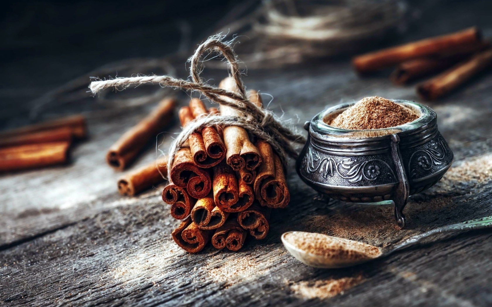 Палочки корицы на столе с молотой корицей