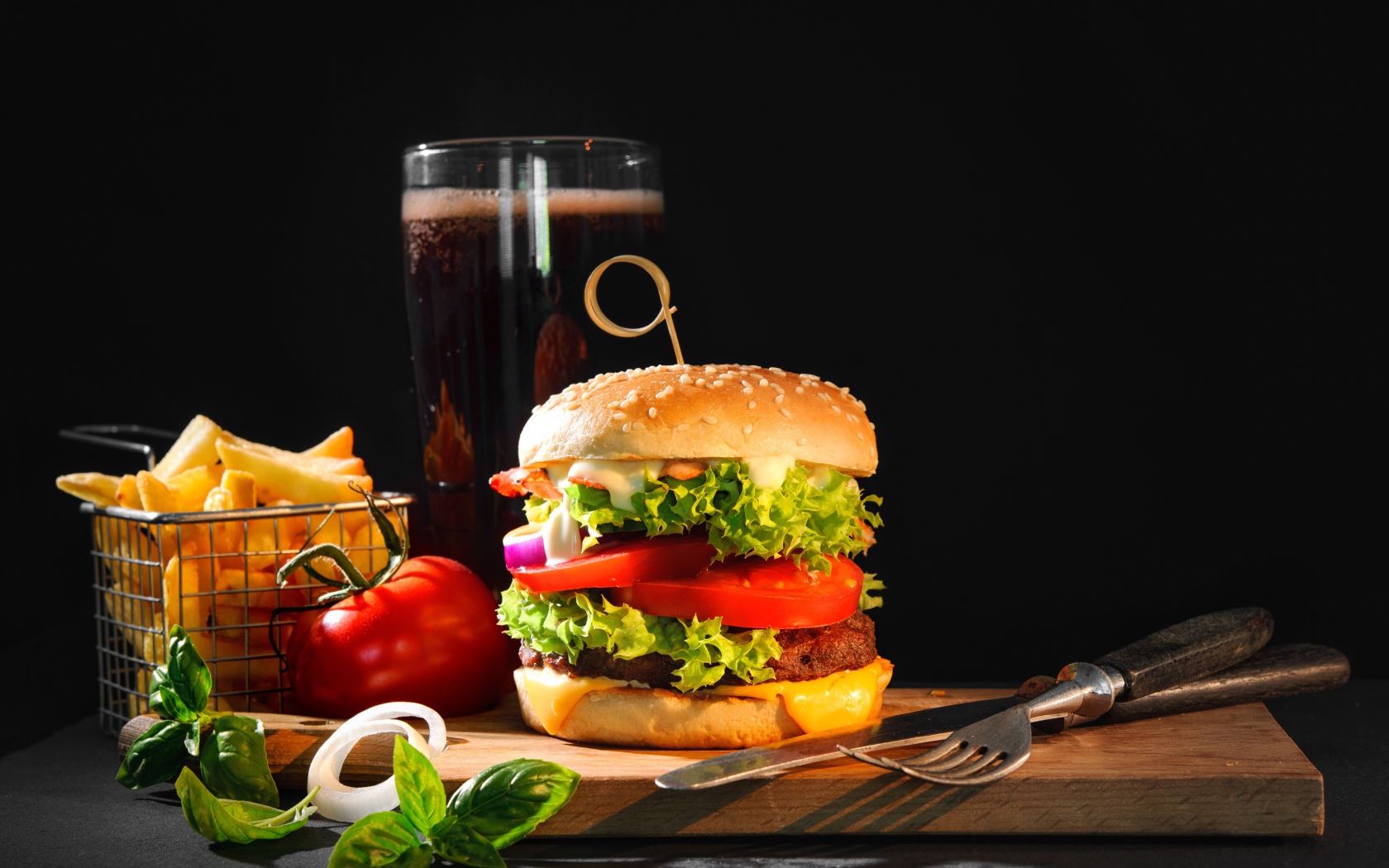 Вкусный аппетитный гамбургер на столе с пивом и картофелем фри