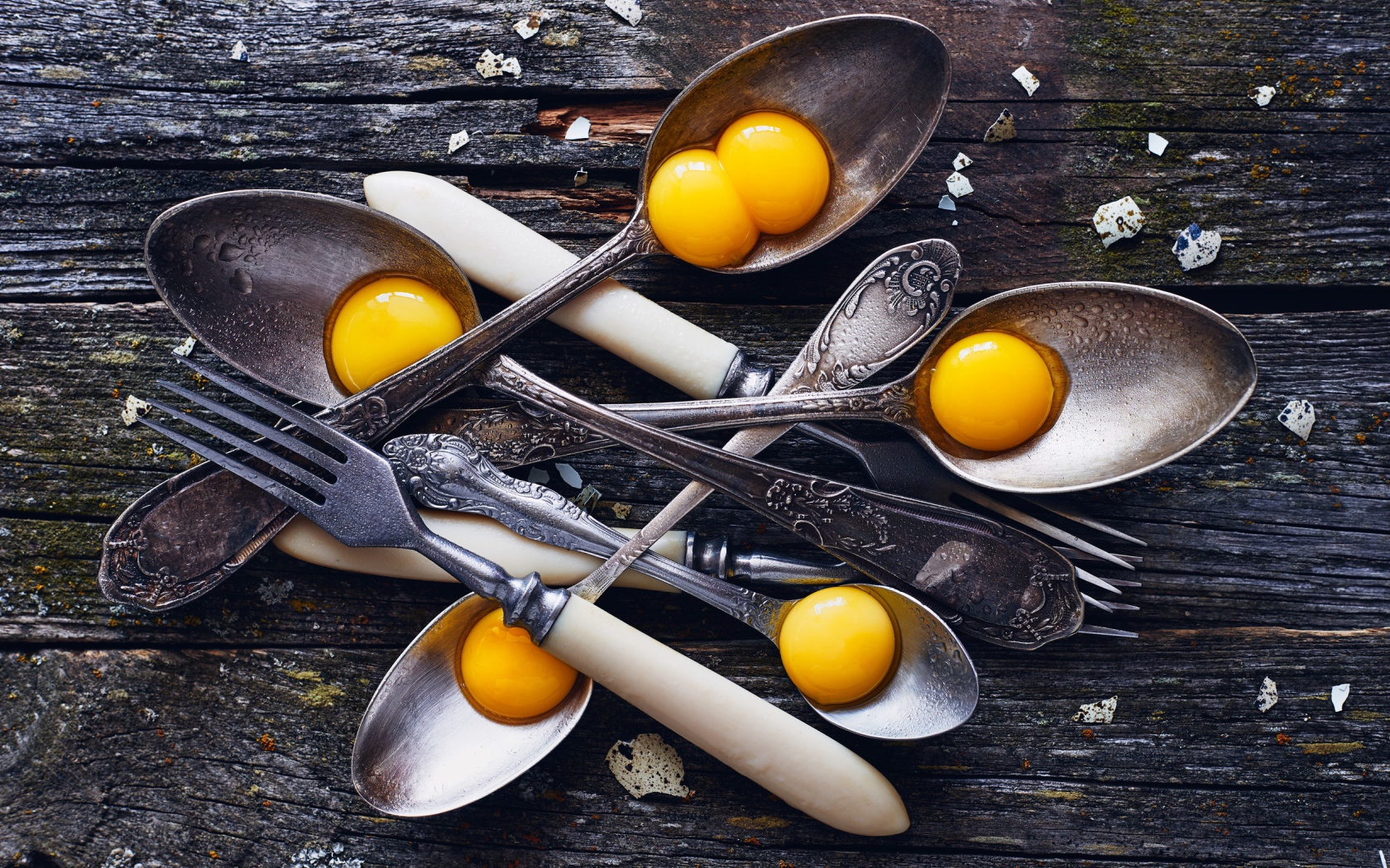 Старые ложки с желтками на деревянном столе