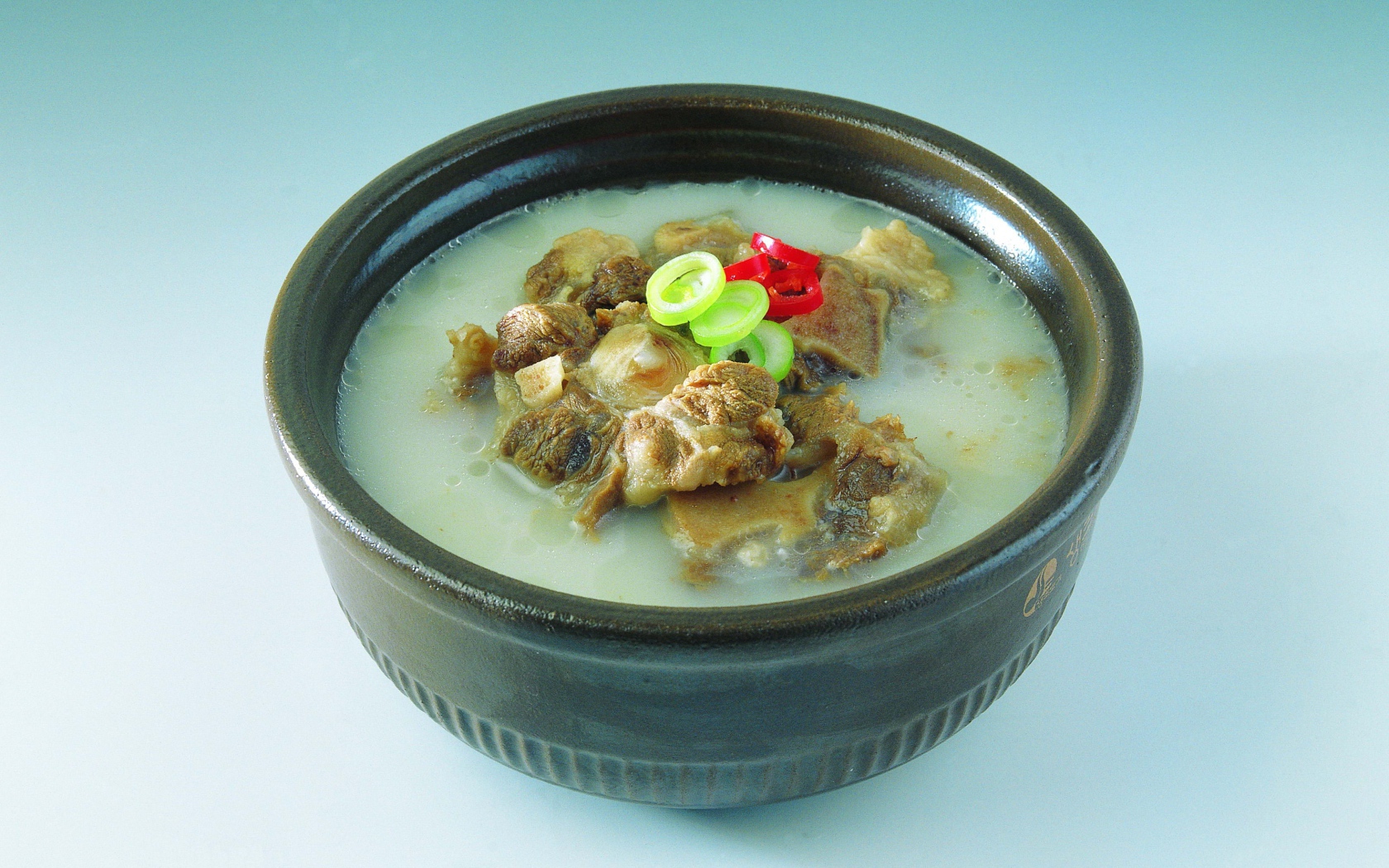 Тарелка супа с говядиной  на голубом фоне