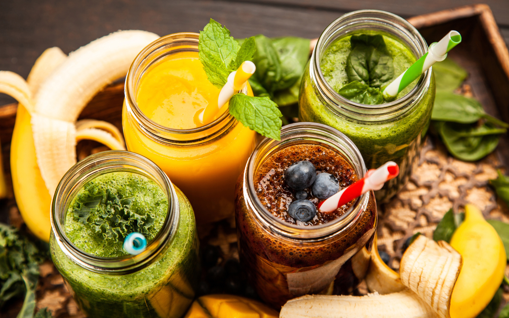 Банки со смузи на столе с бананами