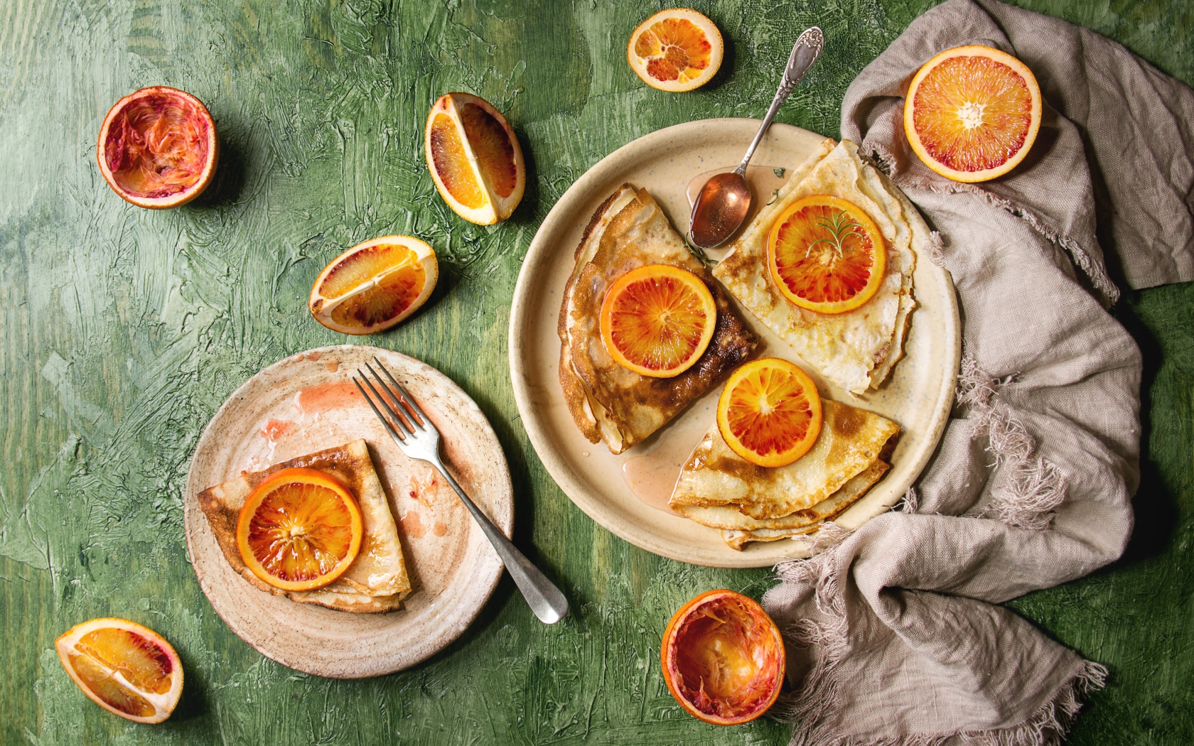 Тонкие блинчики с апельсинами на столе