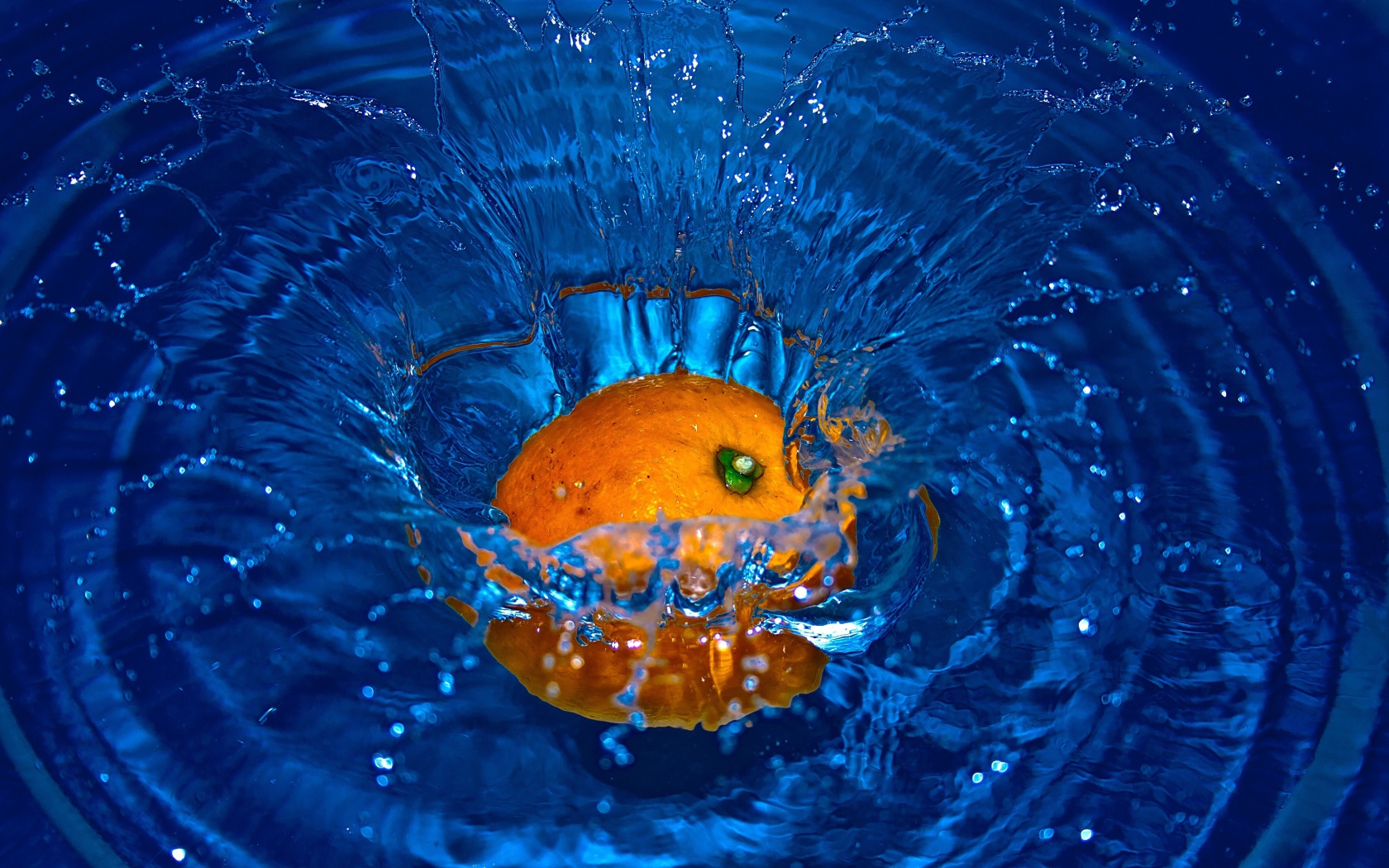 Оранжевый апельсин упал в воду 