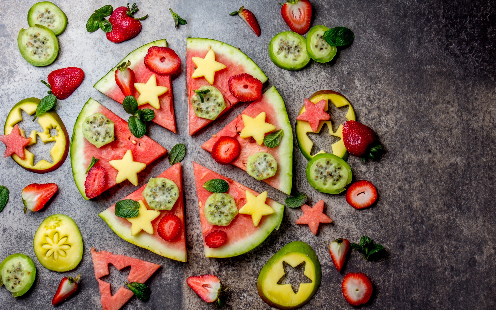 Кусочки арбуза с фруктами на сером фоне