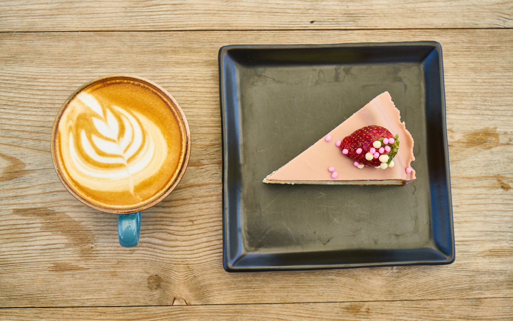 Кусок торта на черной тарелке с кофе