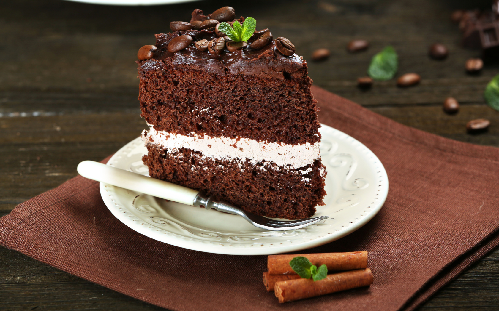 Кусок шоколадного торта с кремом и зернами кофе