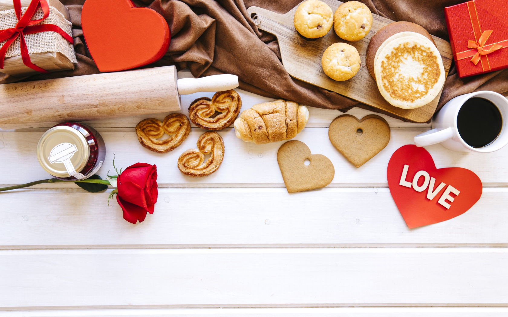 Аппетитная сладкая выпечка на столе с кофе, сердечками и подарками 