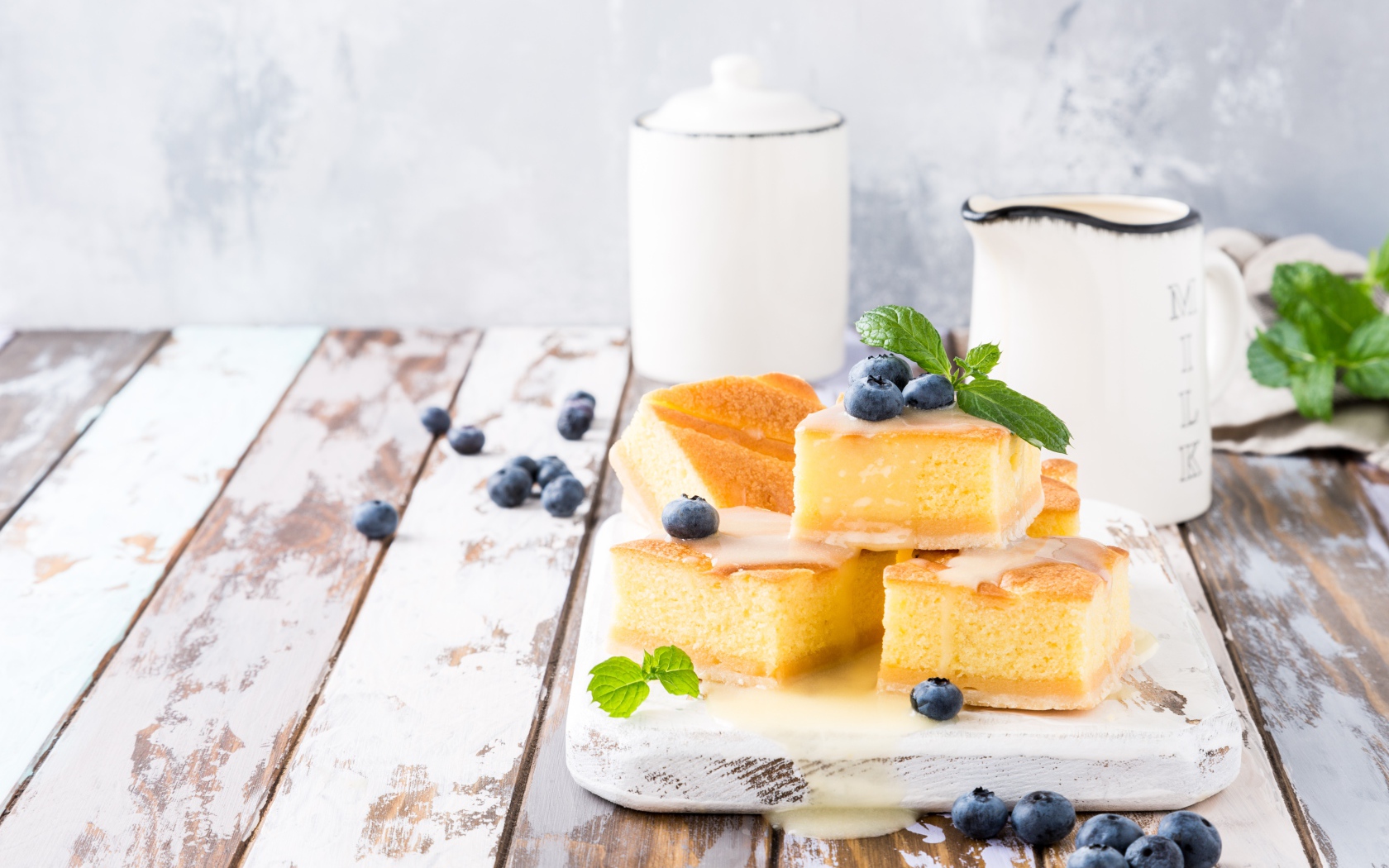 Кусочки бисквитного пирожного на столе с ягодами черники