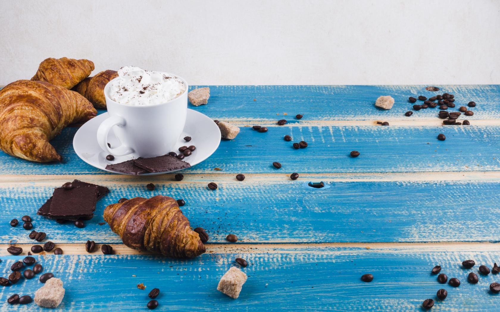 Круассаны на столе с напитком и шоколадом