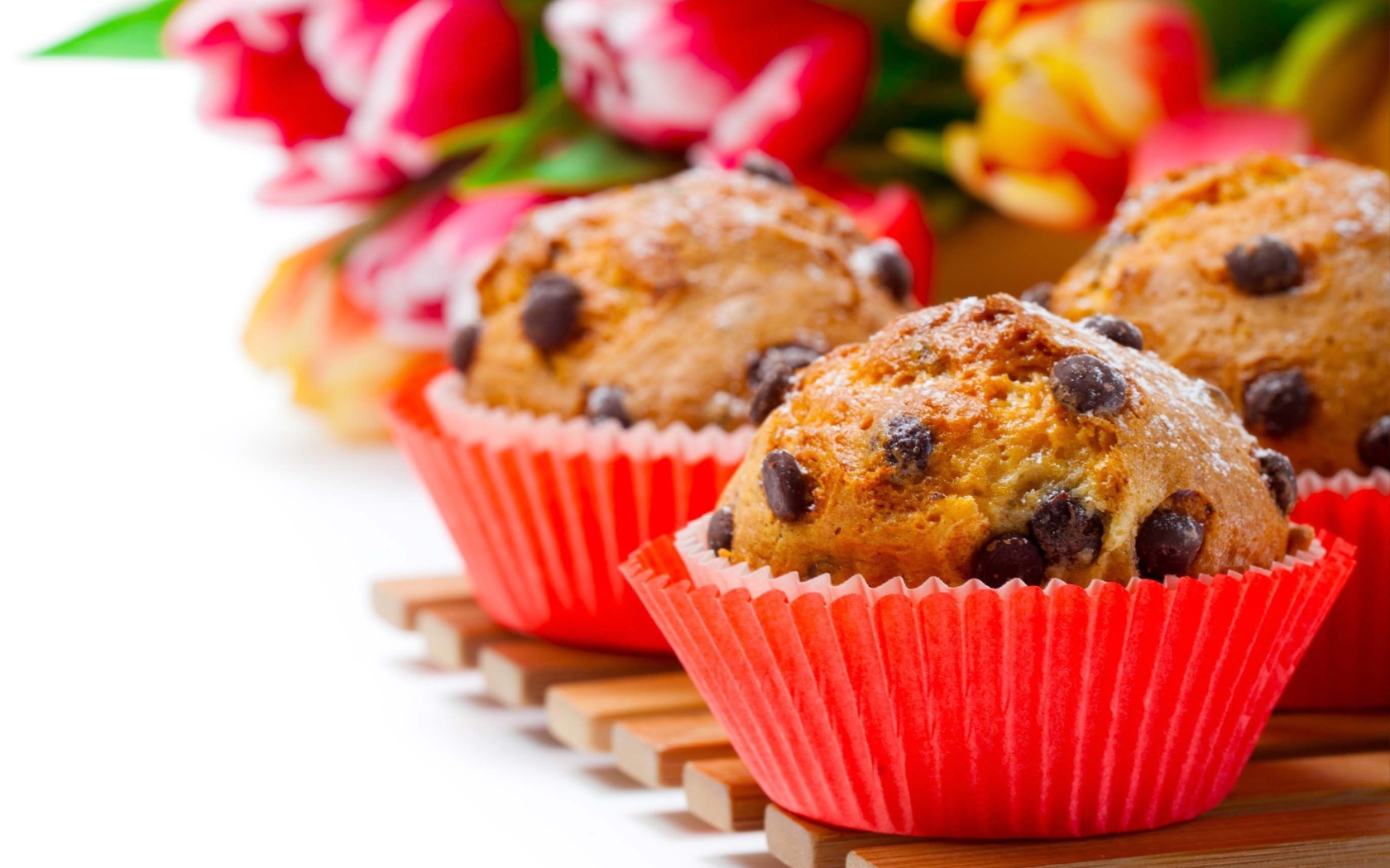 Кексы с шоколадом на белом фоне с букетом тюльпанов 