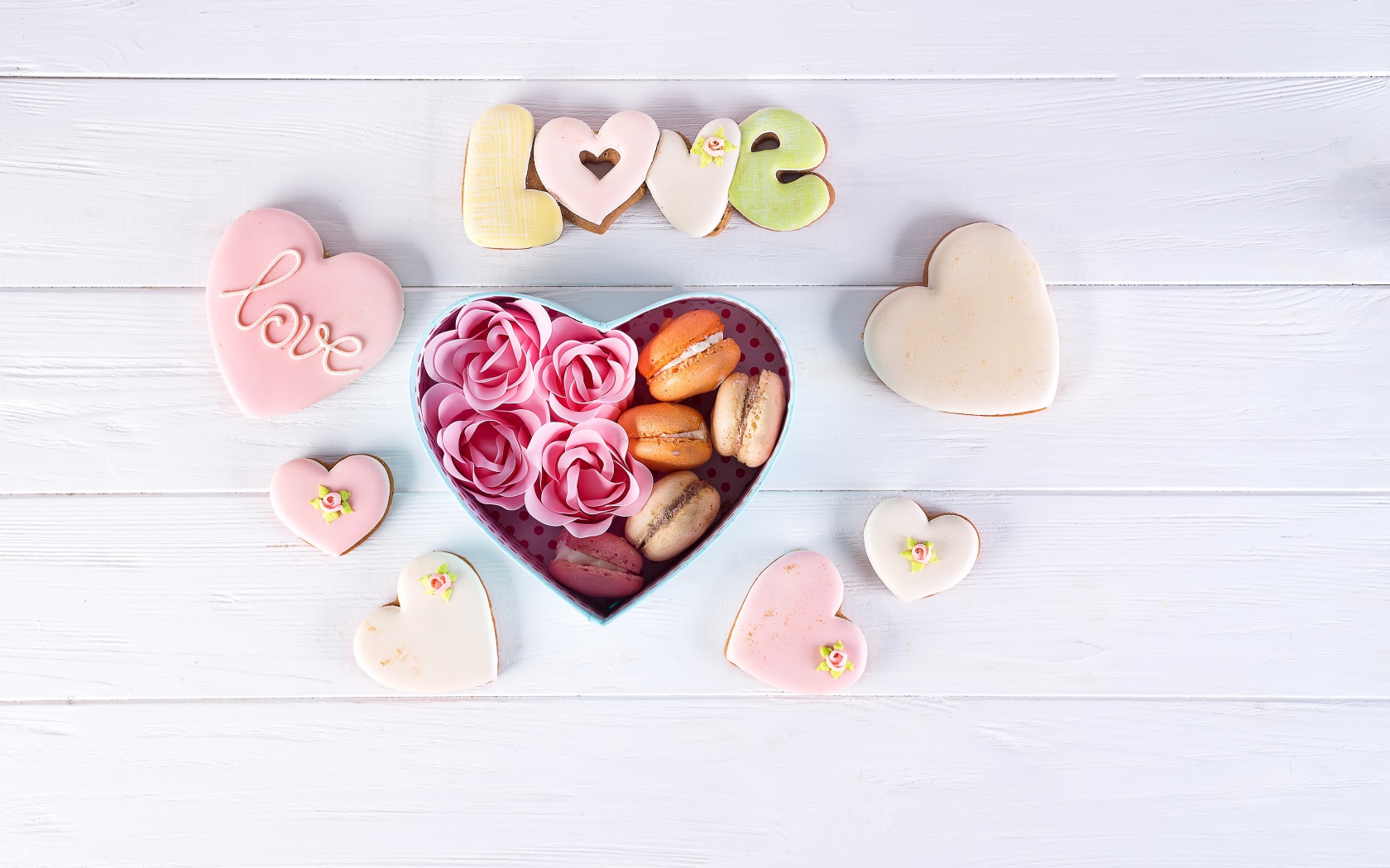 Печенье в форме сердца на столе с коробкой с десертом макарун