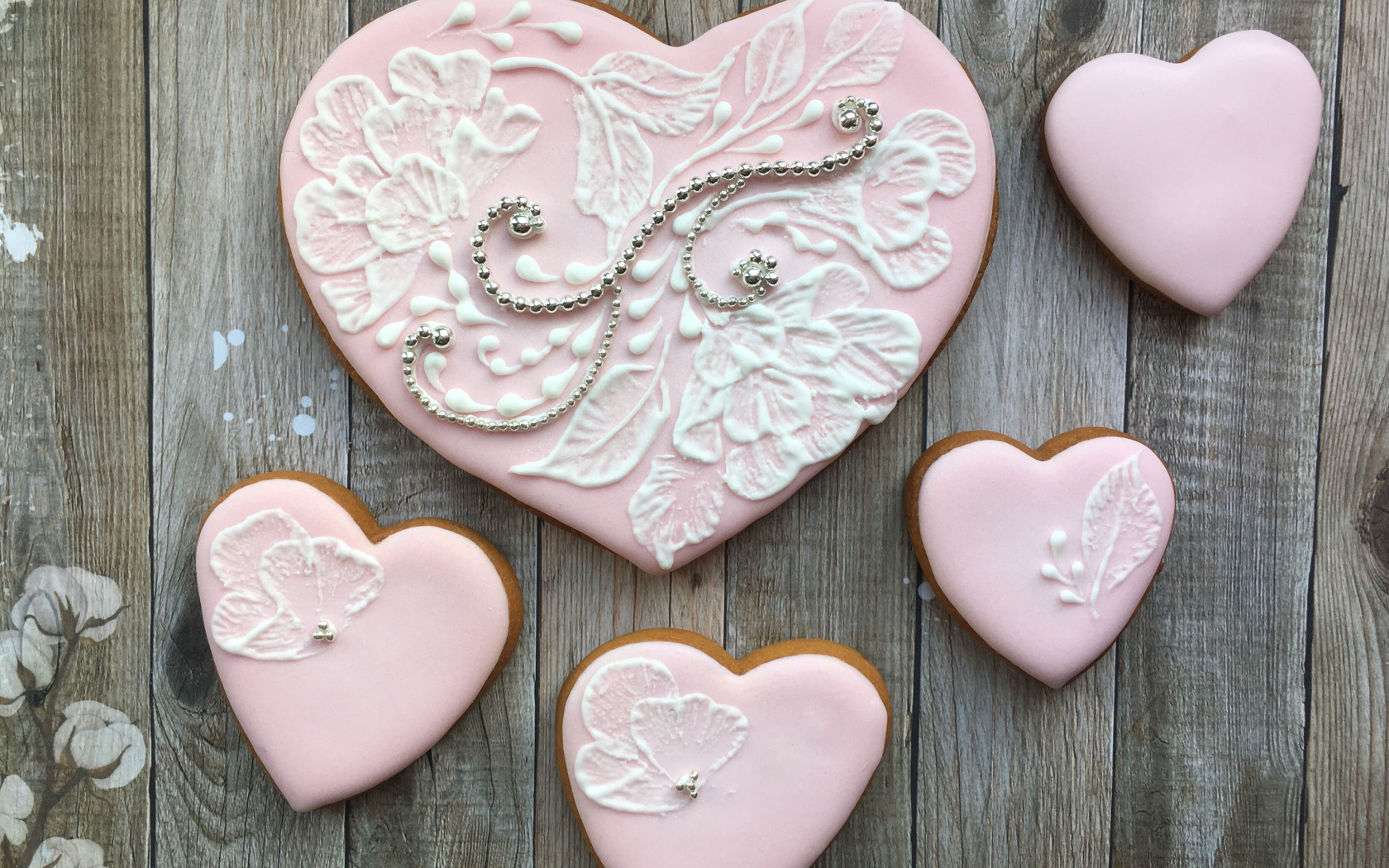 Печенье в форме сердца с розовой глазурью на столе