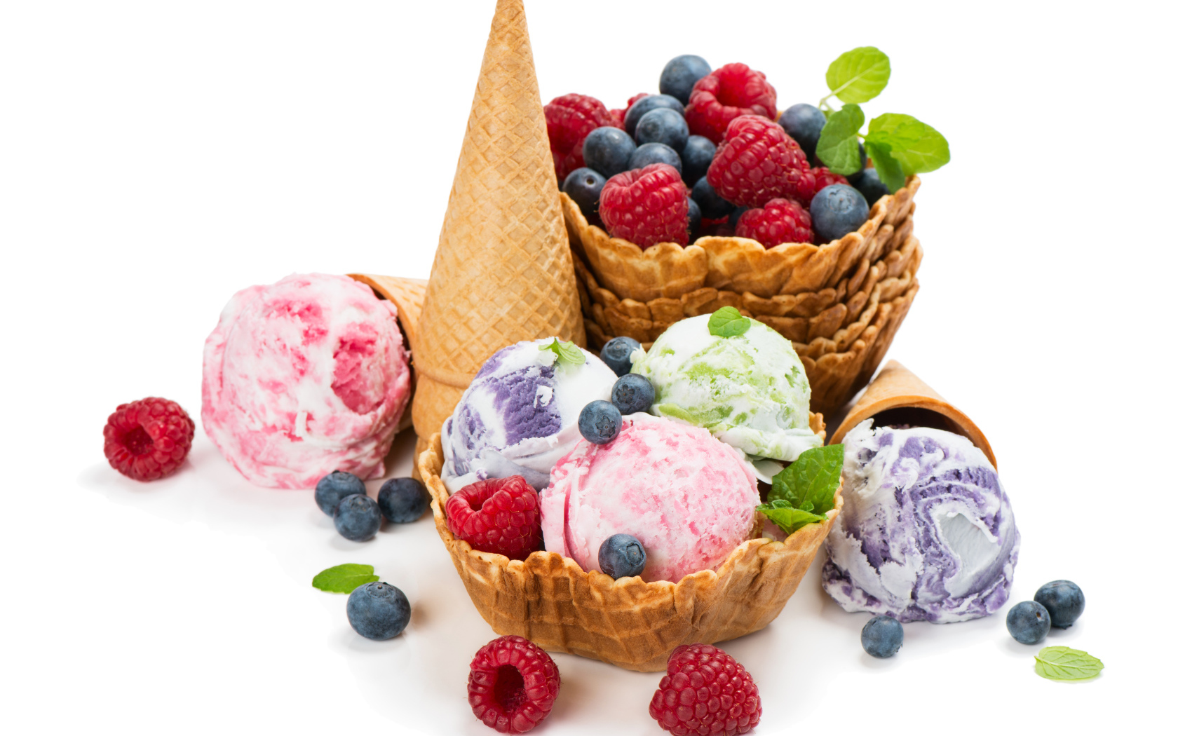 Шарики мороженого на белом фоне с вафлями и ягодами 