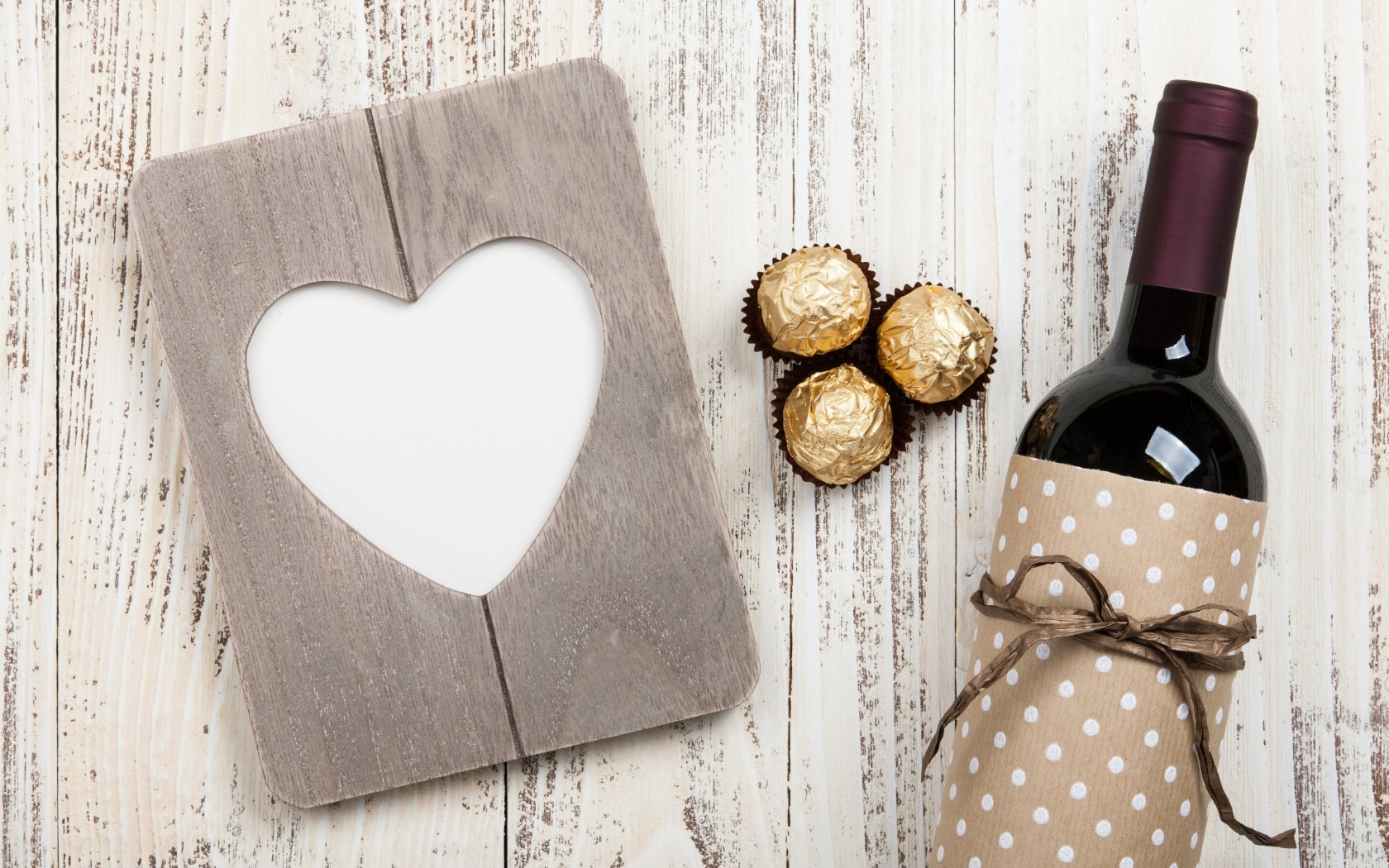 Бутылка вина на столе с конфетами и сердцем 