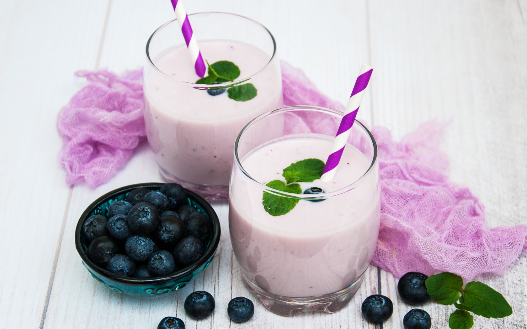 Коктейль в стаканах на столе с ягодами черники