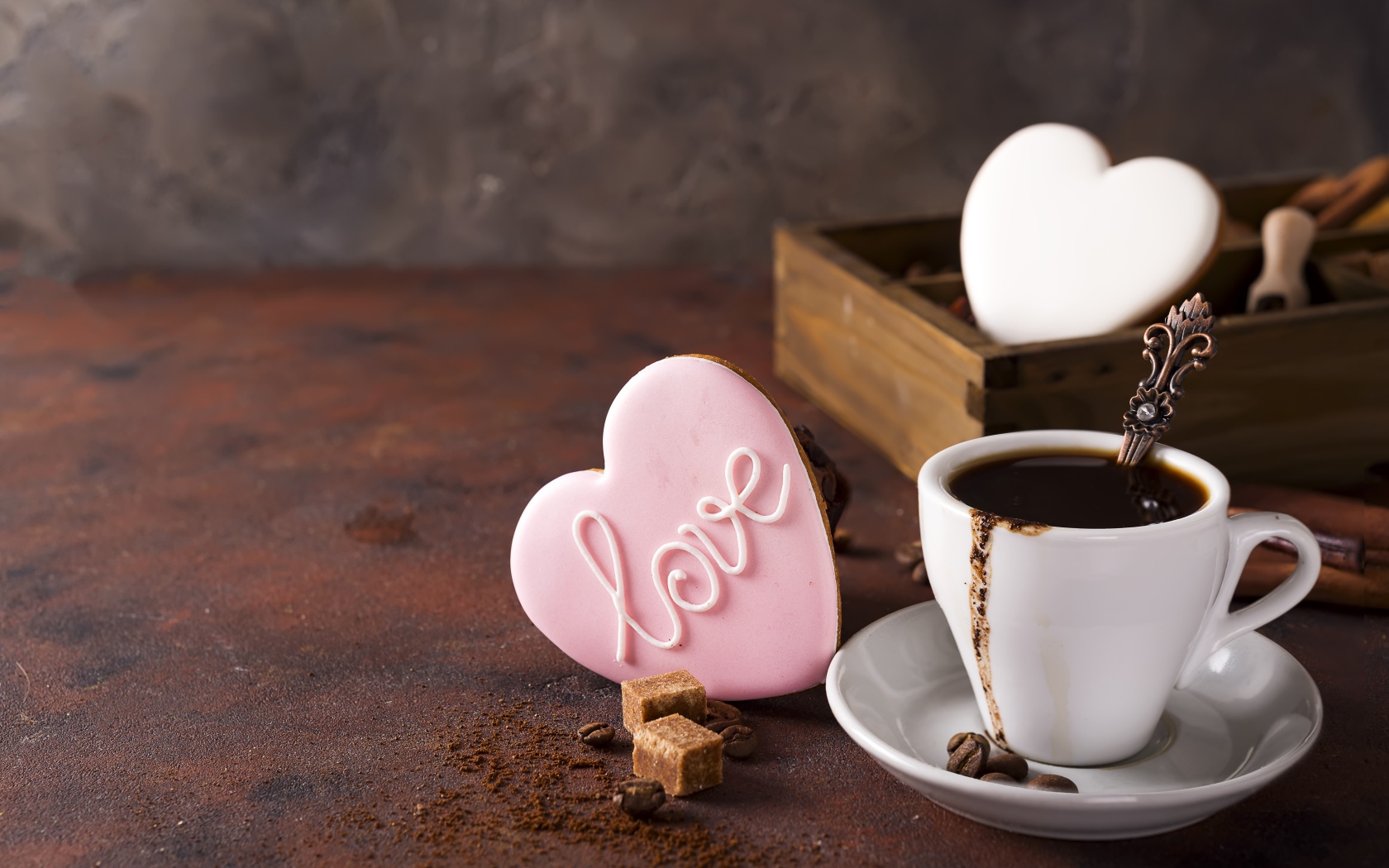 Чашка кофе на столе с сахаром и печеньем в форме сердца 