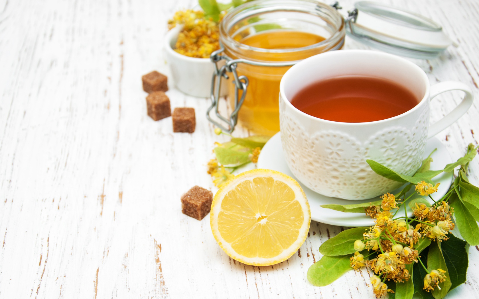 Липовый чай на столе с медом, лимоном, и сахаром