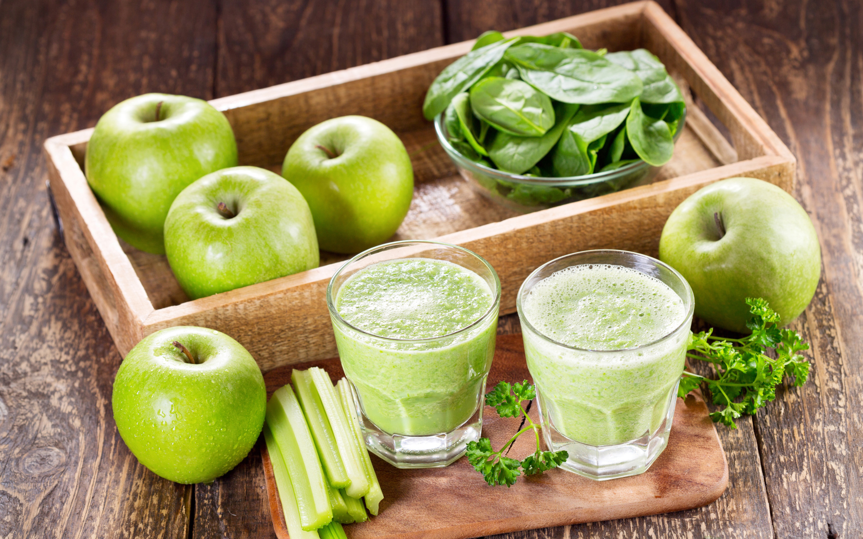 Смузи на столе с зелеными яблоками и зеленью 