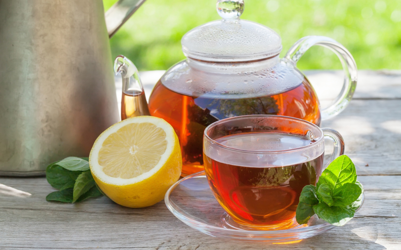 Чайник с чаем на столе с чашкой и половиной лимона