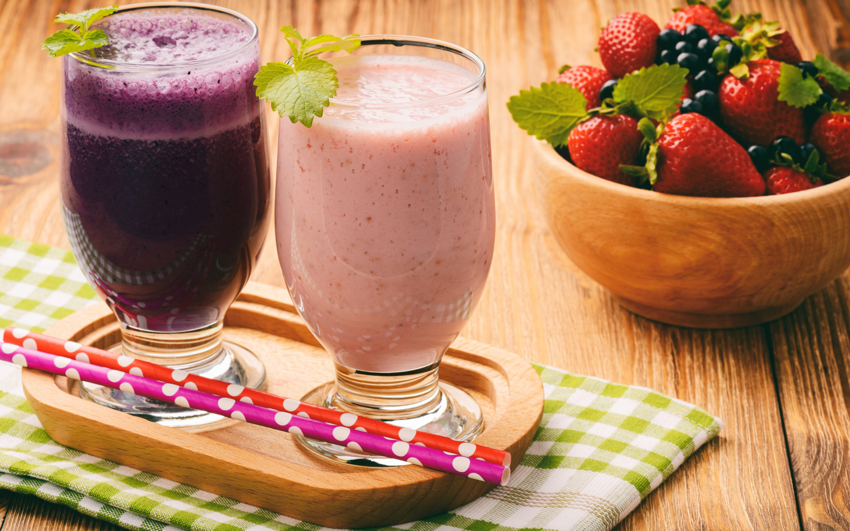 Два стакана смузи на столе с ягодами