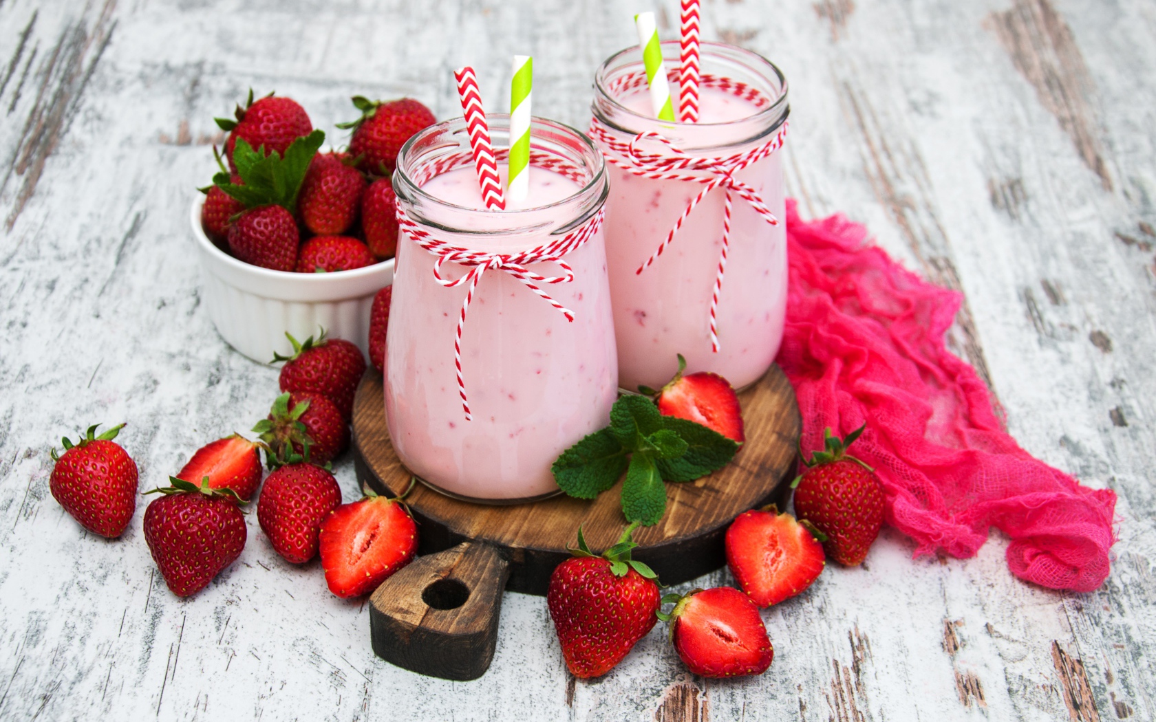 Две банки смузи стоят на доске на столе с клубникой